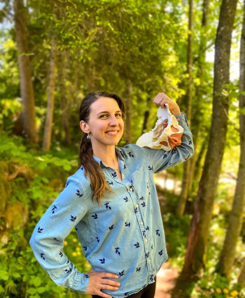 Physiotherapeutin Adriana Igras steht in Vorchdorf im Wald mit einem Beckenboden auf dem Oberarm